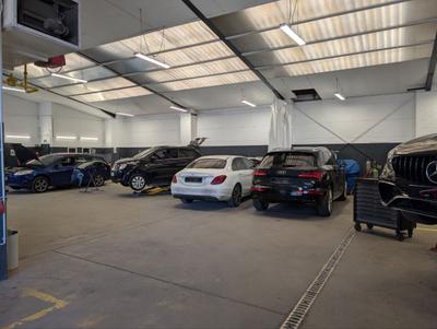 Werkstatthalle mit mehreren Fahrzeugen in Reparatur