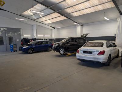 Gro&szlig;e Werkstatthalle mit Mercedes und Ford in Arbeit