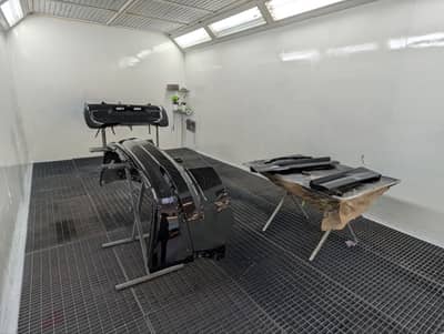 Lackierkabine mit Kotfl&uuml;gel und Karosserieteilen in Vorbereitung